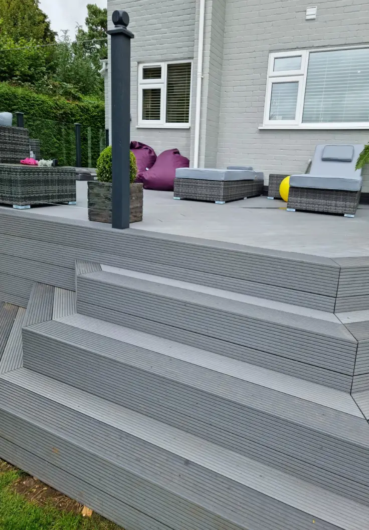 Evaluated Decking Installation With Contrast Colour Steps And Glass Balustrades - Garden Slope Decking Ideas