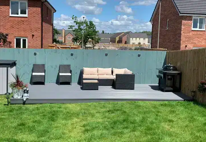 Decking Installed On Uneven Ground With Painted Fences and Garden Furniture