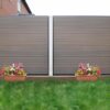Mixed Colour Brown Composite Fencing In Garden With Plants