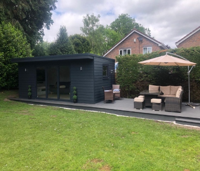 Outdoor freestanding deck with hanging umbrella and outdoor garden room