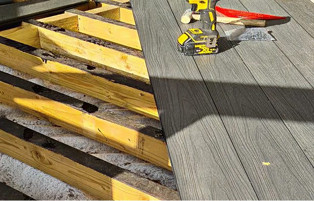 Grey Capped Decking Boards Being Laid With Painted Joists