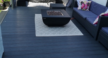 White Outdoor Rug On Dark Grey Decking With Fire Pit