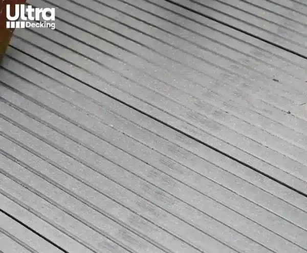 Grooved composite deck board with scratches